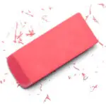 Pink school eraser with shavings on a white background